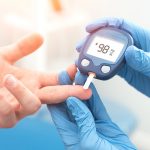 Doctor checking blood sugar level with glucometer